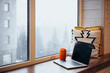 © ADDICTIVE STOCK - Cozy home office setup with laptop and thermos cup by window