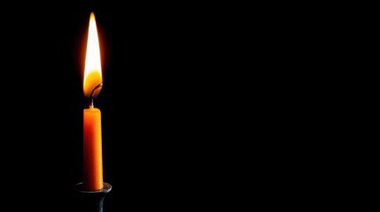 Poster - A single candle glowing elegantly against a black background with golden flames creating a warm ambiance