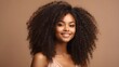 © Malaika - African American girl in a beauty image with clear, healthy skin on a beige backdrop.  A dreamy, gorgeous ebony woman with a smile. Curly hair styled in an afro