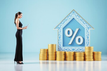 Poster - Woman in black dress using tablet near stacked gold coins and ornate house-shaped percentage symbol on light blue background. Business concept.