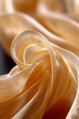 Poster - Luxurious golden silk fabric with soft folds and delicate texture creating a sense of elegance and opulence in a studio setting
