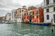 © Connect Images - Colorful historic buildings line a canal in Venice, Italy, with boats moored alongside. Venice, Italy