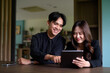 © Ranta Images - Young Asian couple sitting together in library