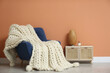 © New Africa - Knitted merino wool plaid on armchair in room