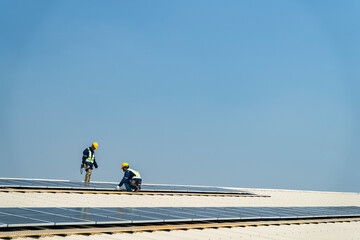Wall Mural - two engineers install solar panels on a rooftop, wearing safety gear and helmets. the scene showcase