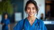 © Arnik - Confident smiling woman doctor in blue uniform with a stethoscope in a hospital shows professional healthcare