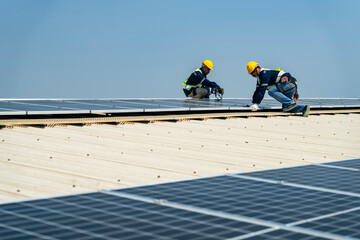 Wall Mural - two engineers install solar panels on a rooftop, wearing safety gear and helmets. the scene showcase