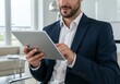 © GS-Studio - A businessman in a suit engrossed in a tablet, showcasing modern technology and work