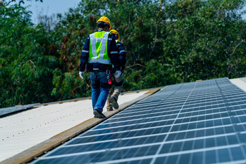 Wall Mural - two engineers install solar panels on a rooftop, wearing safety gear and helmets. the scene showcase