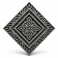 Ornate gray diamond shaped object with floral pattern isolated on a white surface casting a shadow
