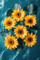 Wall Mural - Sunflowers with green leaves floating on rippled blue water surface, summer feeling