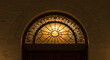 © RIKO - Starburst Patterned Leaded Glass Transom Window Above Arched Doorway