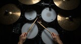 Overhead view of a drummer playing a drum set with drumsticks in hand