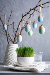 Aufkleber -  A vase with branches holding colorful eggs hanging from the ceiling.
