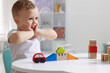 © New Africa - Motor skills development. Little boy playing with toys at white table indoors