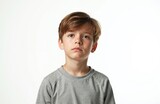 Portrait of sad boy isolated white background. Young male child with serious expression. Unhappy face studio shot. Portrait of Caucasian child with sorrow and childhood emotion. Concept of loneliness.