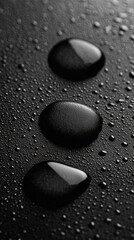 Poster - Three black pebbles with water droplets on them. The image has a moody and mysterious feel to it
