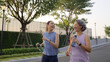 © ChayTee - Young adult child workout outdoor public park run walk hold water bottle with mature middle age old mum. Love health care older mom asia elder people happy family protect aging fun joy city life sport