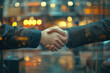 © Birzhan - Two people shaking hands in a city at night, illuminated by bright city lights, showcasing a gesture of agreement and connection amidst the urban hustle.