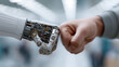 © pattozher - Unity between Human and Machine: A close-up shot of a human fist bumping with a metallic robot hand. This image conveys themes of connection, futuristic technology, and artificial intelligence.