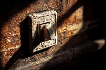 Aufkleber - Close-up of old wooden light switch on rustic wooden surface, illuminated by sunlight, showcasing texture and age, representing nostalgia, history, and simplicity