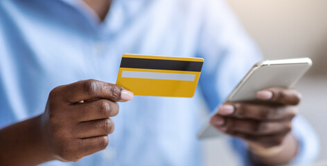 Poster - Online Payment. Unrecognizable black female using smartphone and credit card in office, cropped image, closeup