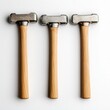 © khonkangrua - Three hammer tools with wooden handles arranged in a row on a light surface for crafting and repair purposes