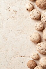 Poster - Smooth rounded stones with varying textures scatter across a light sandy surface, evoking the essence of desert landscapes and natural beauty