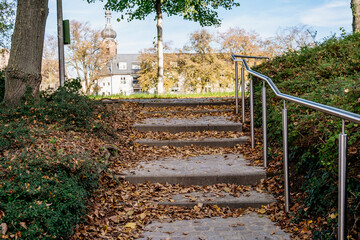 Wall Mural - staircase with leaves on the ground and a railing