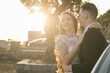 © satura_ - Bride and groom standing in golden sunlight after ceremony. Joy, new beginnings and emotional connection on a wedding day.
