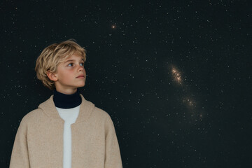 Wall Mural - A young boy is looking up at the stars