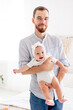 © Any Grant - a happy dad with a little newborn daughter, the concept of fatherhood, a dad on maternity leave with a baby in his arms, a cute photo of a dad with a daughter