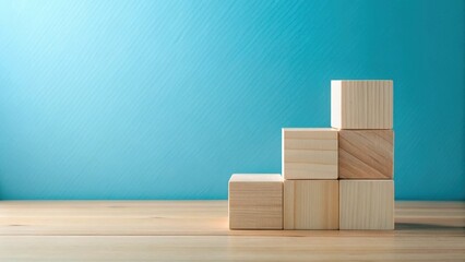 Fototapete - Simple Wooden Blocks Arranged on a Light Wood Surface Against a Blue Background