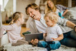 © Geber86 - Family at home using a digital tablet in the living room