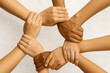 © Kannan - Diverse Human Hands Forming a Unity Circle by Holding Wrists Against a White Background with Tamil Script — Symbol of Teamwork, Cultural Inclusion, and Global Solidarity
