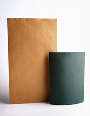 Aufkleber - Paper sheets on white. Tan paper stands tall. Dark green paper curves to the side. Simple backdrop for text or design. Smooth surface of paper texture. Different color paper for craft projects.