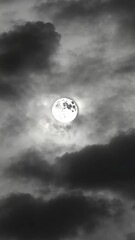 Wall Mural - Bright full moon glows amidst a dark, cloudy night sky, creating a striking celestial view