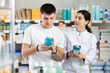 © JackF - In sales area of pharmacy, guy examines packaging of mouthwash solution, read characteristics and properties, check expiration date, storage conditions. Pharmacist in background offer similar product