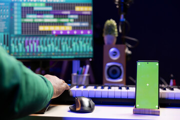Poster - African american musician working on editing new music with a greenscreen, operating on mixing console and stereo gear in home studio. Skilled audio engineer improving sound quality.
