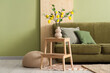© Pixel-Shot - Interior of living room with green sofa, tree branches and lemons in vase