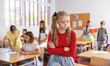 © JackF - Upset tween girl sitting on table in schoolroom during recess on background with other pupils..