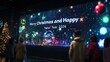 © Chotijah - People admiring a digital display celebrating Christmas and the new year