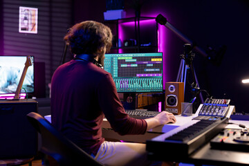 Leinwandbilder - Sound engineer working in his home studio with daw software on computer and mixing tools, creating music. Producer mixing and mastering soundtracks, signal processing acoustical engineering.