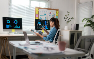 Fototapete - Businesswoman analyzing financial data on computer and digital tablet in modern office