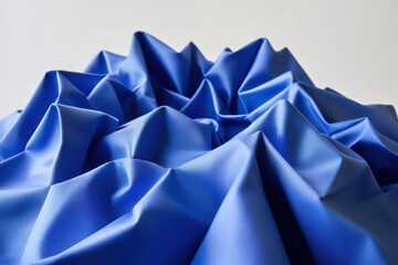 Poster - Captivating close up of vibrant blue fabric folds creating a mountain range effect on a neutral background for texture and design