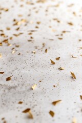 Poster - Festive golden confetti scattered on a white fabric background creating a celebratory mood perfect for party invitations and holiday promotions