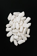 Poster - Elegant pile of white marble stones on black background a minimalist composition in studio shot top view