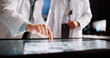 © peopleimages.com - Scientist, hands and pointing with screen for lab review, medical research or teamwork. Computer table, interactive display and clinical analysis for science data, people meeting and study results