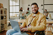 © AnnaStills - Portrait of handsome and confident developer smiling at camera while typing on keyboard of laptop