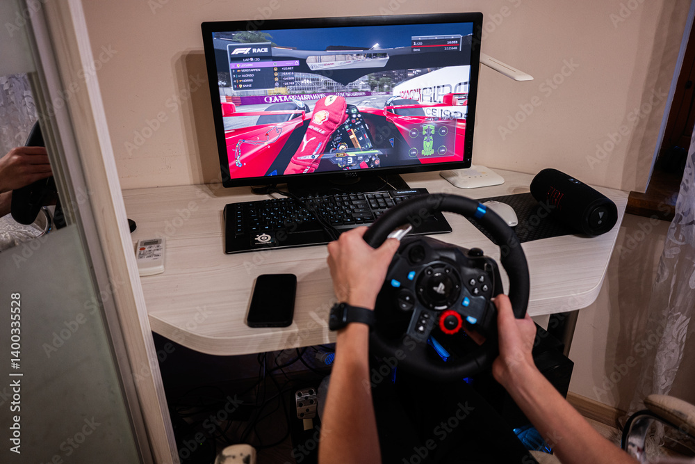 Person gaming F1 Race with a steering wheel and monitor in immersive ...